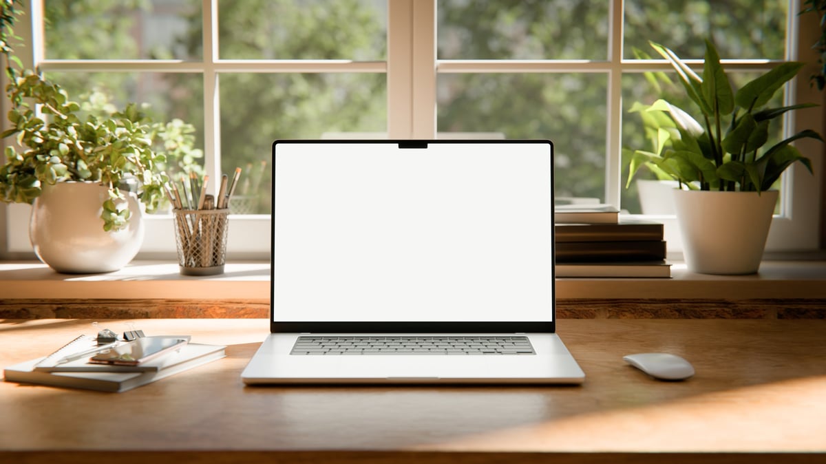 laptop screen mockup images captured in a bright industrial loft interior, placed on a wooden desk near large windows with natural daylight